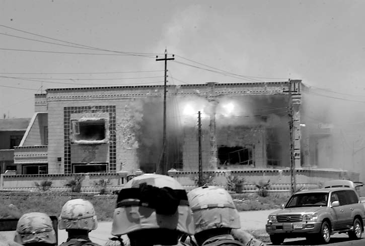 Soldiers assigned to the 101st Airborne Division (Air Assault) look on as a tube-launched optically-tracked wire-guided (TOW) missile penetrates a building where Uday and Qusay Hussein, the sons of Saddam Hussein, barricaded themselves.